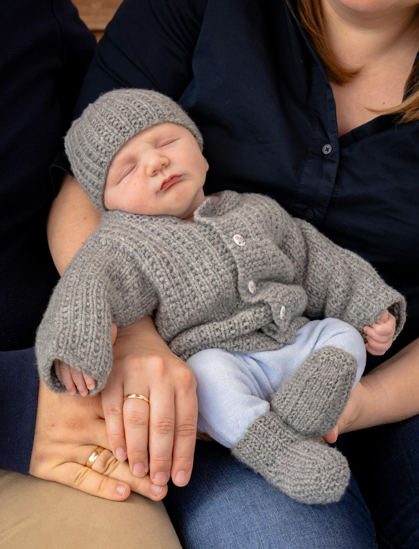 sleeping baby in the arms of his parent